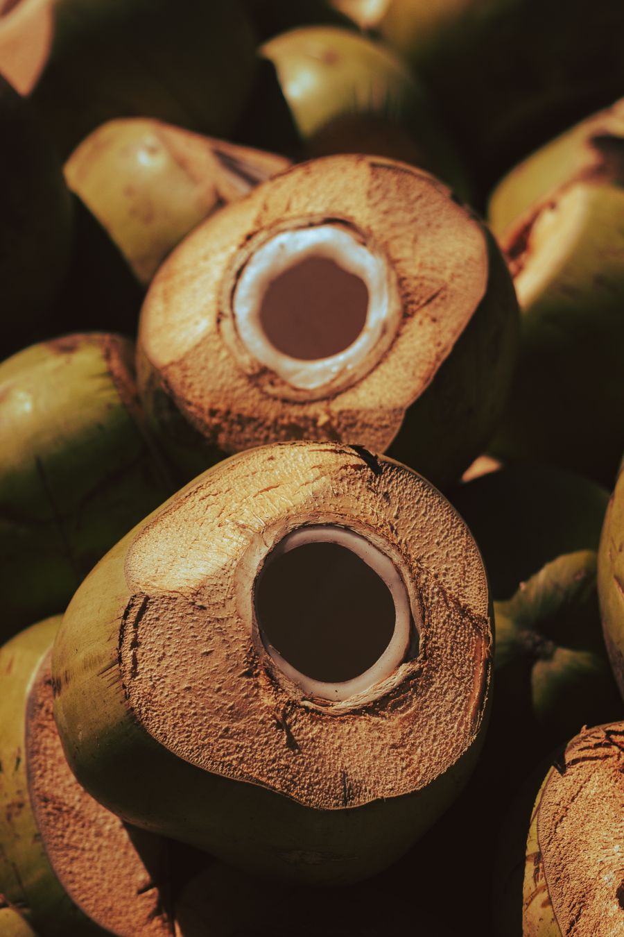 Kelapa muda dibuka dengan lubang minum, isi putih kelihatan di bibir potongan